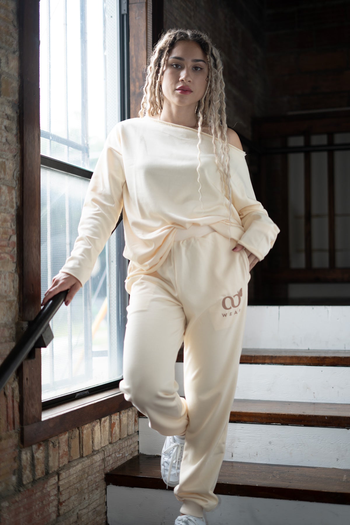 This Off-white 2-piece loungewear set for women, including a sweatshirt and pants. Designed for everyday comfort or travel, it offers a relaxed and laid-back style. Made from breathable, high-quality materials, it's both popular and sustainable, making it a must-have addition to any wardrobe.